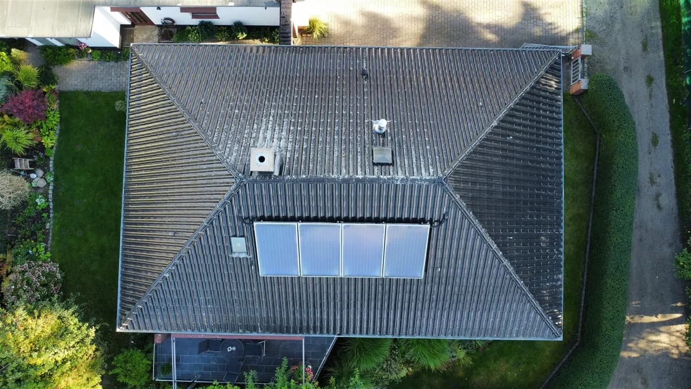 Luftbild von oben: Walmdach mit Schornstein, Entlüftung, Dachfenster und Solarkollektoren