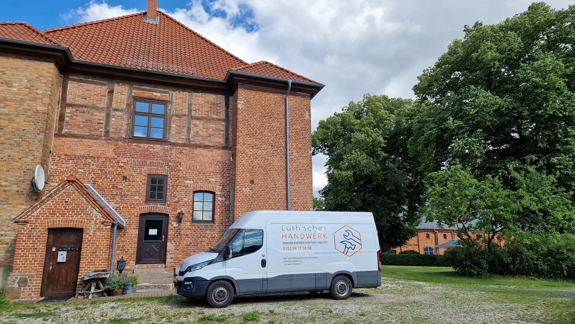 Firmenfahrzeug von Lüthsches Handwerk vor einem Haus mit Ziegeldach